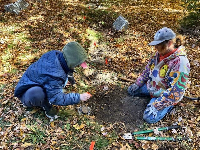 Jay Lown and Eileen Szymanski bringing metal burial markers back to ground level